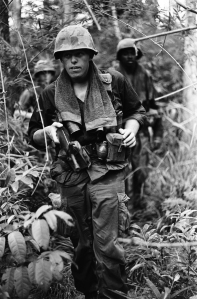 A-file-of-soldiers-on-a-routine-jungle-patrol.-Haughey-says-most-soldiers-wore-towels-around-their-necks-like-this-one-did-to-help-combat-sweat-in-the-jungle-heat.-Names-date-and-location-unknown