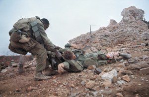 16 Feb 1968, Hue, South Vietnam --- A U.S Marine keeps his head low as he drags a wounded buddy from the ruins of the Citadel's outer wall during fighting. --- Image by © Bettmann/CORBIS