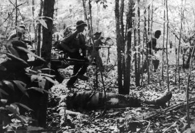 A Viet Cong detachment going into battle during the Vietnam War, January 1967. In the foreground is the body of a dead American soldier. (Photo by Keystone/Hulton Archive/Getty Images)