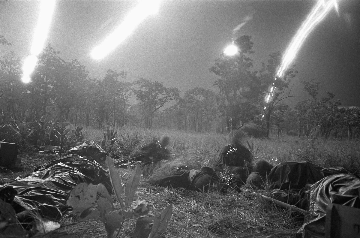 Flares from planes light a field covered with dead and wounded of ambushed battalion of the U.S. 1st Cavalry Division in the Ia Drang Valley, Vietnam, November 18, 1965. During fierce battle that has been raging since Nov.14, 1965. Units of the division have been battling to hold its lines against what is estimated to be a regiment of North Vietnamese soldiers. Bodies of the slain soldiers were carried to this clearing with their gear to await evacuation by helicopter. (Rick Merron/AP Photo)