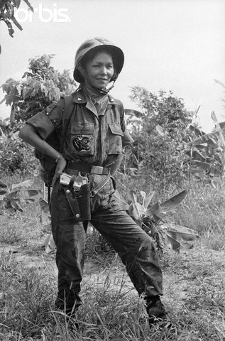 19 Jun 1965, South Vietnam --- A pearl-handled .45 automatic on her hip, HoThi Que - "Tiger Lady" of the vital MeKong Delta in Suth Viet Nam watches the 44th Vietnamese Ranger Battalion march into the jungle in pursuit of Red Viet Cong Guerrillas. The Battalion - Recently awarded the US Presidential Citation for Extraordinary Hero- is under the command of Major de Van Dan, who is her husband. --- Image by © Bettmann/CORBIS