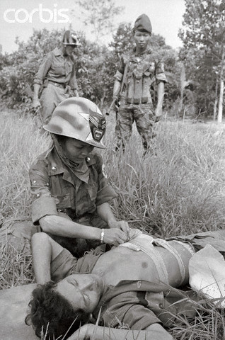 19 Jun 1965 --- When the "Tiger Lady" isn't actually fighting alongside her husband and his Rangers, she helps to care for the wounded in the field. Her presence in the combat zone has contributed importantly to the high morale of the 44th South Vietnamese Ranger Battalion. The unit's Tiger head insignia appears on her helmet. --- Image by © Bettmann/CORBIS